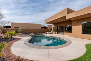 Integrated pool / hot tub featuring a patio area and a fenced backyard