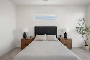 Bedroom with light colored carpet and baseboards