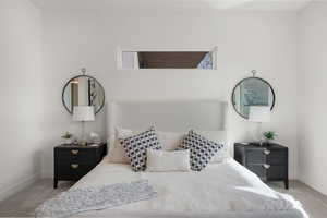 Bedroom featuring light carpet and baseboards