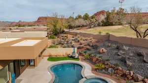 Integrated pool / hot tub with a fenced backyard, a mountain view, and a patio