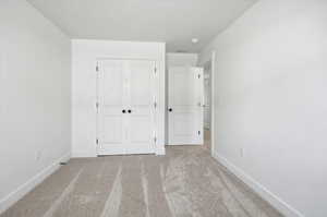 Unfurnished bedroom with carpet and a closet