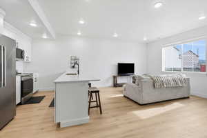 Living room with light wood finished floors and recessed lighting