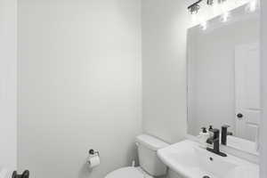 Half bathroom with toilet and a sink