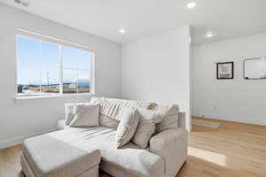 Sitting room with light wood-style flooring and recessed lighting