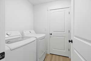 Laundry room with light wood-style floors and independent washer and dryer