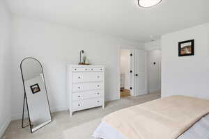 Bedroom featuring light carpet and baseboards