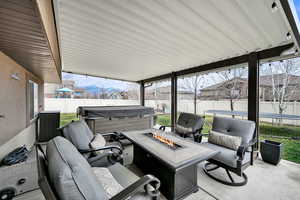 Fenced backyard featuring a mountain view, a trampoline, a patio area, and an outdoor living space with a fire pit