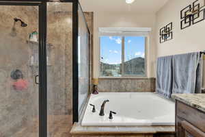 Bathroom featuring a whirlpool tub, a stall shower, and vanity