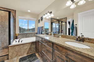 Bathroom with a stall shower, a garden tub, and double vanity