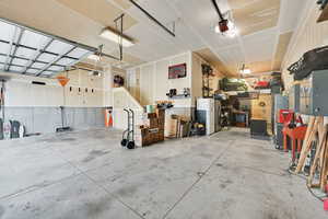 Garage with white fridge with ice dispenser and a garage door opener