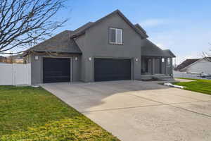 Traditional home featuring a gate, stucco siding, concrete driveway, and roof with shingles