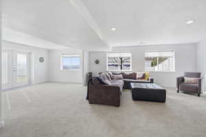 Living room featuring carpet flooring, french doors, recessed lighting, and a textured ceiling