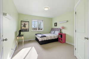 Bedroom featuring baseboards and light colored carpet