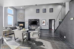 Living room featuring a high ceiling and a glass covered fireplace