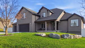 View of front of property featuring an attached garage, stucco siding, driveway, a shingled roof, and covered porch