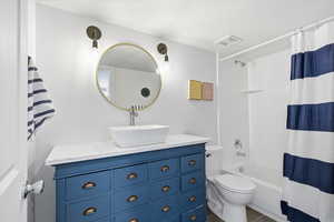 Bathroom with shower / bath combination with curtain, vanity, and dark tile patterned floors