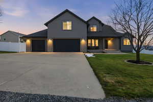 View of front of home with stucco siding, concrete driveway, and covered porch
