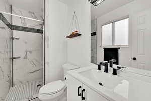 Full bathroom with a marble finish shower and vanity
