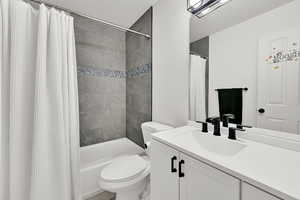 Bathroom featuring vanity, a textured ceiling, and shower / bath combo with shower curtain