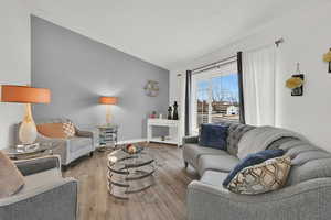 Living area with vaulted ceiling and wood finished floors