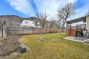 Fenced backyard featuring a deck with mountain view and stairway