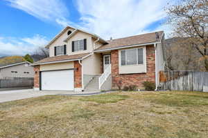 Tri-level home featuring brick siding, an attached garage, concrete driveway, and roof with shingles