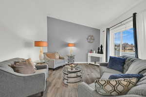 Living area with light wood-style floors and vaulted ceiling