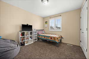 Carpeted bedroom with a closet