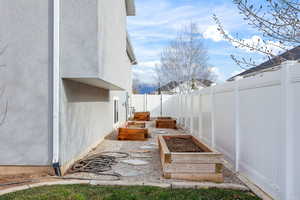 Fenced backyard with a garden and a patio area