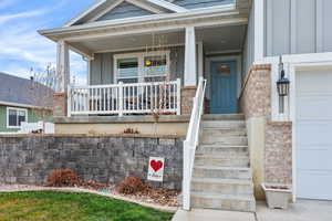 Entrance to property featuring a garage, covered porch, and board and batten siding