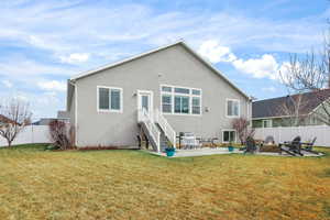 Rear view of house featuring a patio, a fenced backyard, stucco siding, and an outdoor fire pit