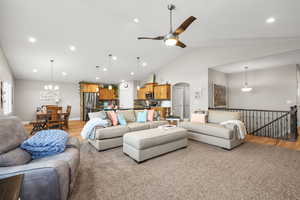 Living area featuring arched walkways, a ceiling fan, recessed lighting, lofted ceiling, and light colored carpet