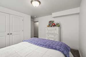 Carpeted bedroom featuring a closet and baseboards