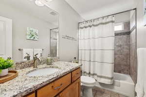 Full bathroom featuring shower / bath combination with curtain, vanity, and light tile patterned flooring