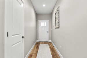 Doorway to outside featuring baseboards and wood finished floors