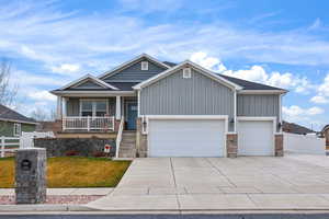 Craftsman inspired home featuring board and batten siding, a porch, driveway, and a garage
