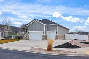 Ranch-style house featuring a gate, concrete driveway, brick siding, and a garage