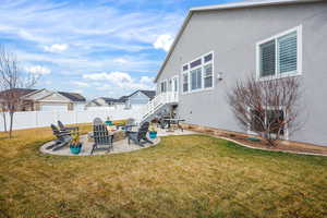 Fenced yard featuring a patio area, an outdoor fire pit, and a residential view