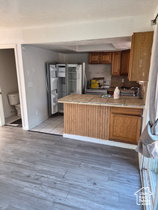 Kitchen with light countertops, a peninsula, dark wood-style floors, and wood finish cabinets
