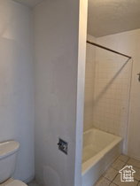 Full bathroom with tile patterned floors and washtub / shower combination