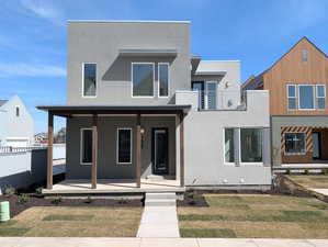 Contemporary home featuring covered porch and stucco siding