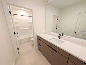 Basement Full bathroom with vanity, light tile patterned floors, and shower / bathtub combination