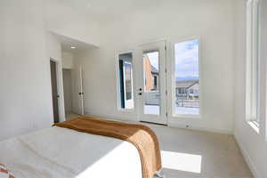 Primary bedroom with access to balcony and 12ft ceilings