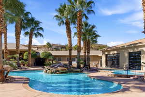 Community pool with a patio area and a hot tub