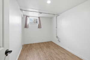 Spare room featuring light wood-style floors and baseboards