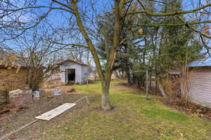 Fenced backyard featuring an outbuilding