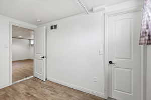 Unfurnished bedroom featuring light wood-type flooring and baseboards