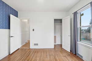 Unfurnished bedroom with light wood-style floors and a closet