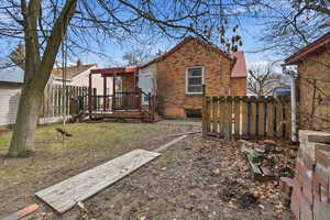 Back of property featuring brick siding and a deck