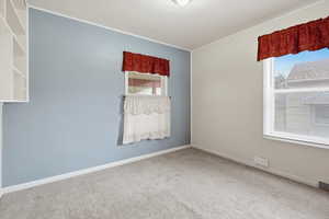 Carpeted spare room featuring baseboards and ornamental molding
